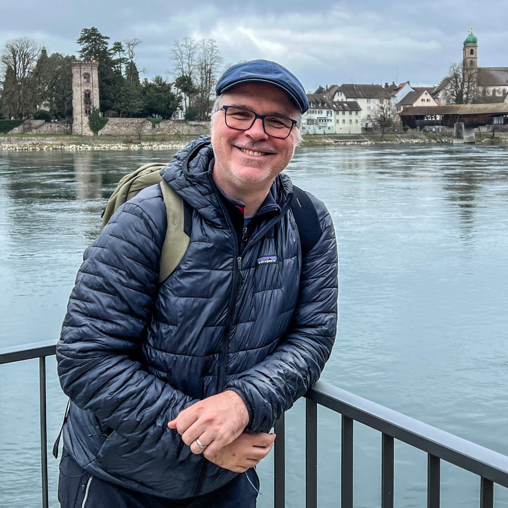Der Wanderleiter geniesst die Wanderung und lacht in die Kamera.