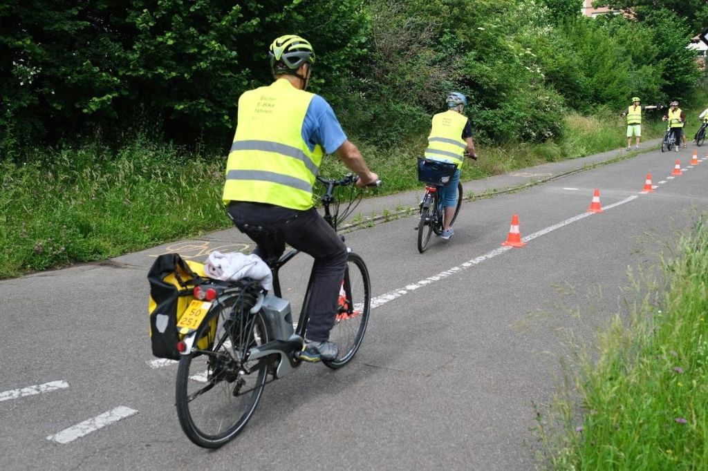 Die Teilnehmenden eines E-Bike-Kurses üben das Slalomfahren auf einer Probestrecke.