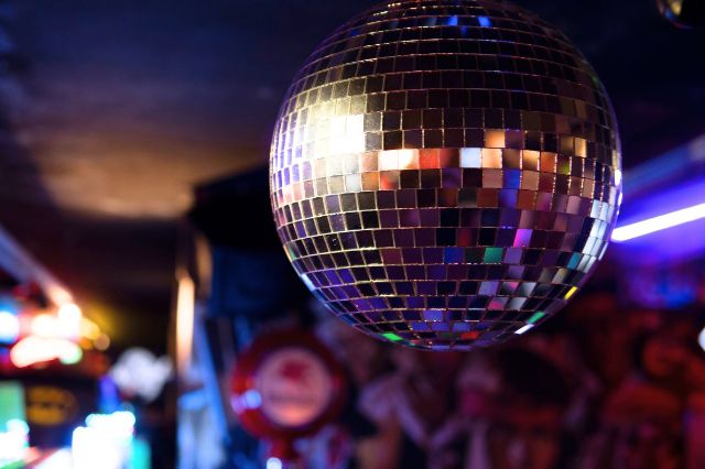 Eine grosse Discokugel auf einer Party glitzert.