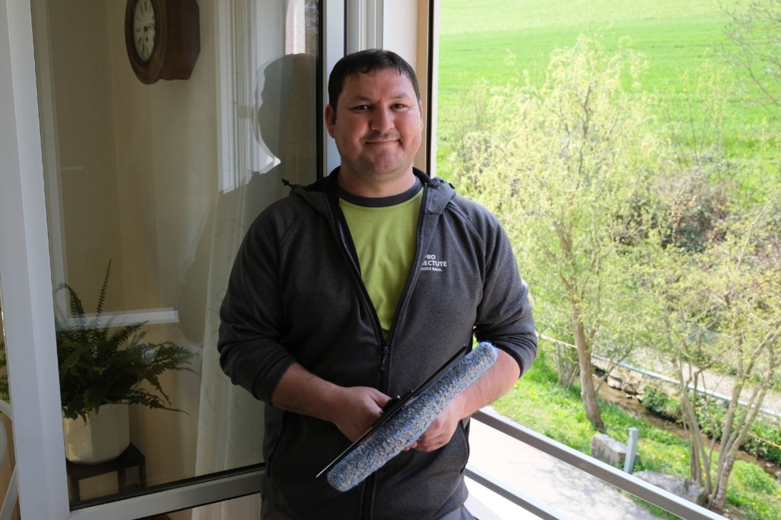 Ersin putzt in einer Wohnung professionell die Fenster.