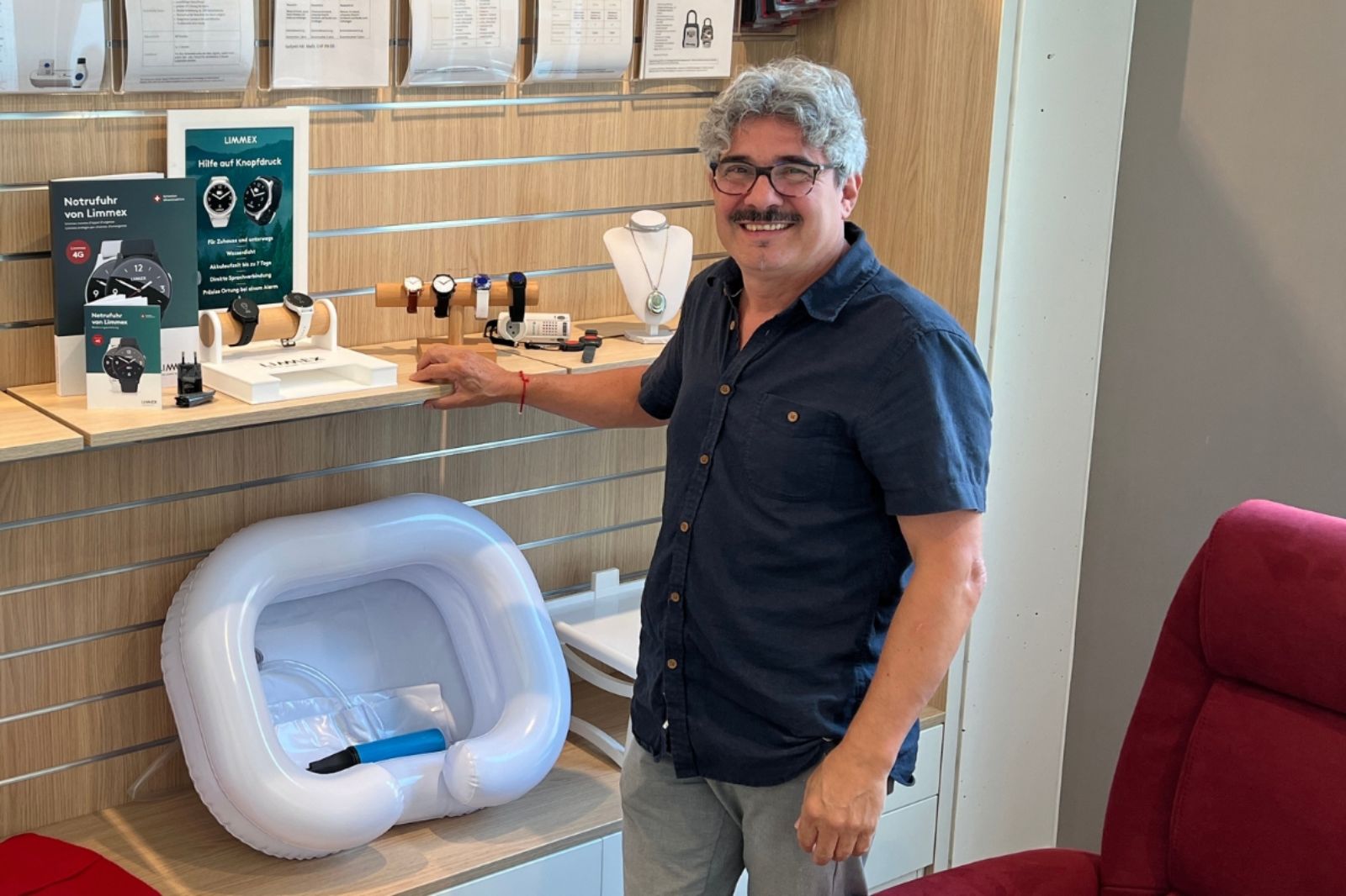 José zeigt im Hilfsmittelshop die neuen Notrufuhren.